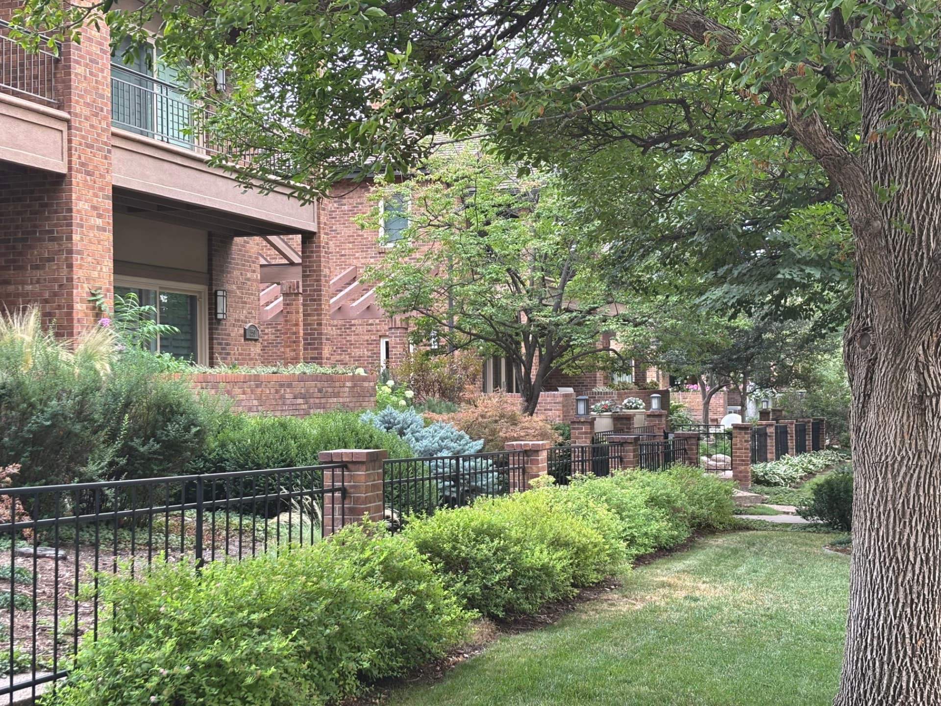 Brick rowhomes and gardens along a Cherry Creek North block